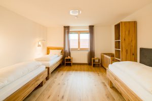 Kinderzimmer mit drei normalen Betten und Gitterbett in Familiensuite