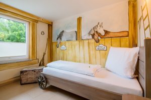 Bett mit Truhe im Kinderzimmer der Ferienhaus Ranch Little Joe