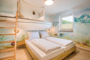 Kinderzimmer mit Doppelbett und Etagenbett in Schiffform im Fischerhaus